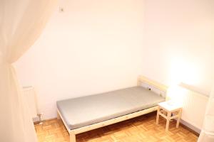a small bedroom with a bed and a table at Stifts-Suite in Klosterneuburg