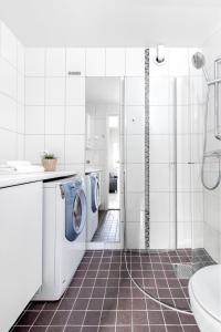 a white bathroom with a washer and dryer at Dal Gjestegaard in Skoppum