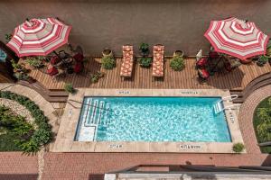 einen Blick über einen Pool mit Sonnenschirmen in der Unterkunft Green Door Lofts -Magnolia Loft, Silos/Downtown in Waco