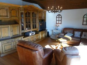 salon z kanapami, telewizorem i stołem w obiekcie Ferienhaus Schäfer - Apartments - Wintersports - Family holiday - Holiday with your dog - Rural & Scenic w mieście Flattnitz