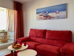 uma sala de estar com um sofá vermelho e uma mesa em Apartamentos Apolo 16 em Calpe
