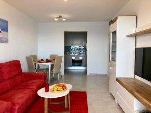 sala de estar con sofá rojo y mesa en Apartamentos Apolo 16, en Calpe