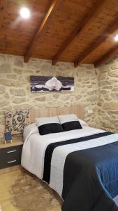 sypialnia z dużym łóżkiem i kamienną ścianą w obiekcie CASA Eiró w mieście Lobios