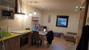 a kitchen with a table and a counter with chairs at CASA Eiró in Lobios