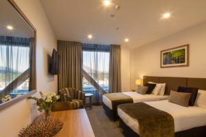 um quarto de hotel com duas camas e uma mesa em Wyndham Garden Queenstown em Queenstown