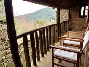 um alpendre com duas cadeiras e vista para uma montanha em Casa do Tanque em Lousã