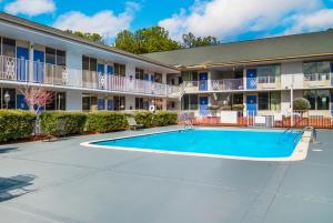 a swimming pool in front of a apartment building at Studio 6 Extended Stay - Lagrange, GA in La Grange