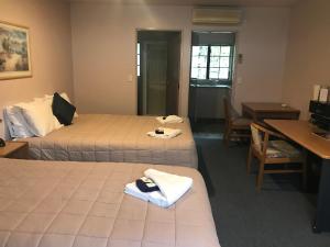Postel nebo postele na pokoji v ubytování Tudor Lodge Motel