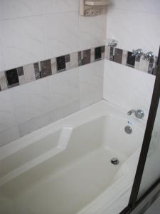 a white bath tub in a bathroom at Hotel Rivera Plaza in Cali