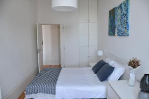 - une chambre blanche avec un lit et une table dans l'établissement Sé Boutique Apartment, à Porto