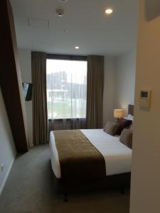 a bedroom with a large bed and a window at Wyndham Garden Queenstown in Queenstown