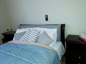 a bed with blue and white sheets and pillows at Minies Beach Villas in Minia