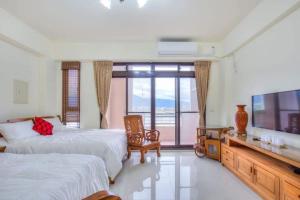 a bedroom with two beds and a flat screen tv at 宜蘭樸實園民宿 in Jiaoxi