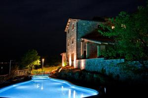 a swimming pool in front of a building at night at Agriresort Le Porcine in Bolsena