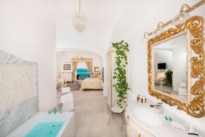 a bathroom with a tub and a mirror at Hotel Villa Gabrisa in Positano