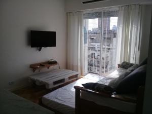 a bedroom with a large window with a view of a city at Sunny Recoleta Apartment in Buenos Aires