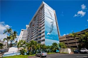 a large building with a picture of a surfer on it at Waikiki 2BR King Beds Short Walk to Convention and Beaches in Honolulu