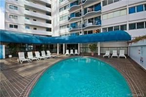a large swimming pool in front of a building at Waikiki 2BR King Beds Short Walk to Convention and Beaches in Honolulu