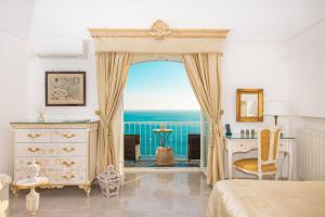a bedroom with a bed and a window with the ocean at Hotel Villa Gabrisa in Positano