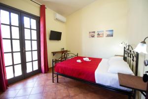 una camera con un letto con una coperta rossa di Guest House Capitan Libeccio a Tropea