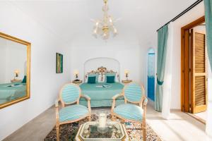 a bedroom with a table and two chairs and a chandelier at Hotel Villa Gabrisa in Positano