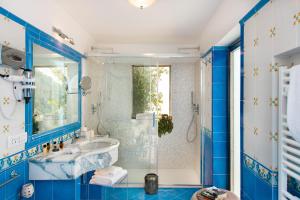 a blue bathroom with a sink and a shower at Hotel Villa Gabrisa in Positano