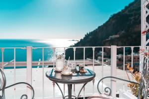 a table on a balcony with a view of the ocean at Hotel Villa Gabrisa in Positano