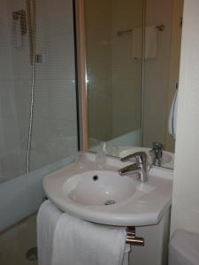 a white bathroom with a sink and a shower at ibis Besançon Marchaux in Marchaux