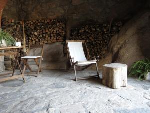 a room with two chairs and a pile of wood at Mas Colom in Sant Joan les Fonts