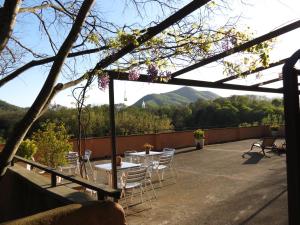 eine Terrasse mit einem Tisch und Stühlen mit Bergen im Hintergrund in der Unterkunft Mas Colom in Sant Joan les Fonts