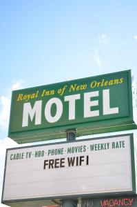 a neon motel sign on top of a store at Royal Inn Of New Orleans in New Orleans
