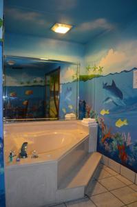 baño con bañera y mural de pescado en Economy Inn New Orleans en Nueva Orleans
