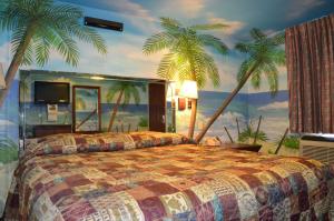 a bedroom with a bed with palm trees on the wall at Economy Inn New Orleans in New Orleans