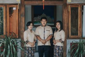 a man and two women standing in front of a door at Cempaka Borobudur Guest House in Borobudur