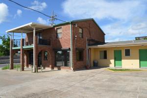 un antiguo edificio de ladrillo con puertas verdes en una calle en Royal Inn Of New Orleans, en Nueva Orleans