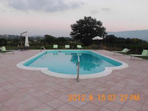 a swimming pool in a patio with chairs around it at Country House L'Ippocastano in Altavilla Silentina