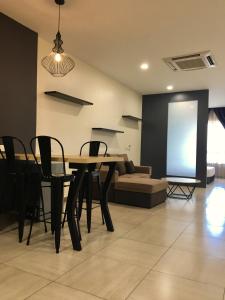a living room with a table and chairs and a couch at PM Octagon Ipoh Suites & Apartment 1 in Ipoh