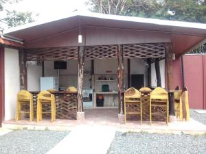 a pavilion with yellow chairs and a kitchen at Cabinas Hukats Secret Jungle in Puerto Viejo