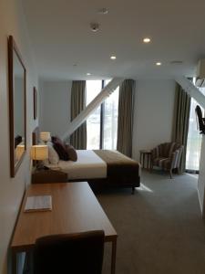 um quarto de hotel com uma cama, uma secretária e uma cadeira em Wyndham Garden Queenstown em Queenstown