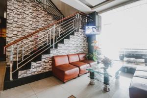 a living room with a couch and a staircase at RedDoorz Plus near Universitas Negeri Makassar in Makassar