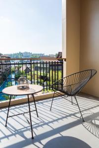 a chair and a table on a balcony with a view at Aurico Kata Resort & Spa - SHA Extra Plus in Kata Beach