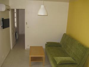 a living room with a green couch and a table at Villa du Lez in Prades-le-Lez