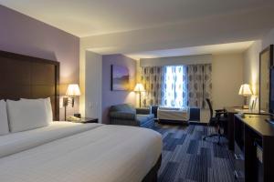 a hotel room with two beds and a television at La Quinta by Wyndham Springfield Airport Plaza in Springfield