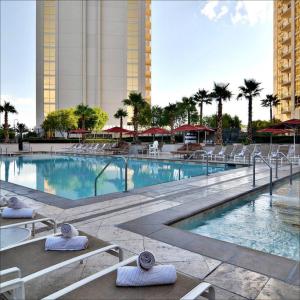 拉斯维加斯Luxury Studio MGM Signature, Great Location, Lazy River, No Resort Fees的带躺椅的游泳池和酒店