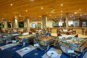 a buffet line with several trays of food in a restaurant at Hotel Sudu Araliya in Polonnaruwa