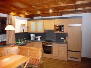 a kitchen with wooden cabinets and a stainless steel refrigerator at Apart Piz Mondin in Pfunds
