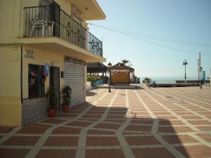 un edificio en una calle con el océano en el fondo en Hostal Flor Blanco, en Torremolinos