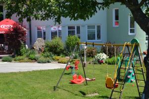 a playground with swings in the grass in a yard at Pension Karawankenblick in Moosburg