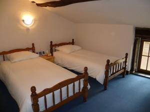 two twin beds in a room with a window at La Belle Grange Bussiere in Bussière-Portevine