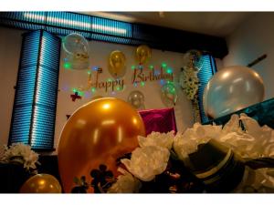 a bunch of balloons and a happy birthday sign next to flowers at XYZ Private Spa and Seaside Resort in Shirahama